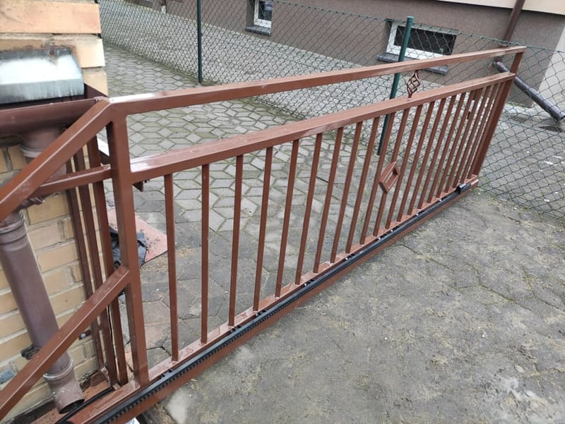 Balustrada z poziomych profili stalowych zabezpieczająca podjazd przy budynku