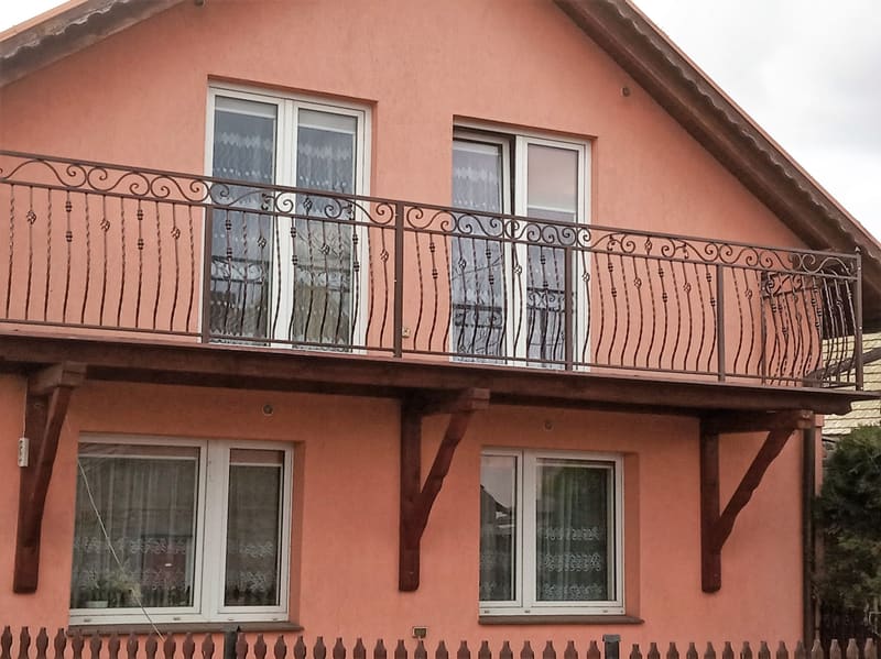 Dwie kute balustrady balkonowe na elewacji domu jednorodzinnego