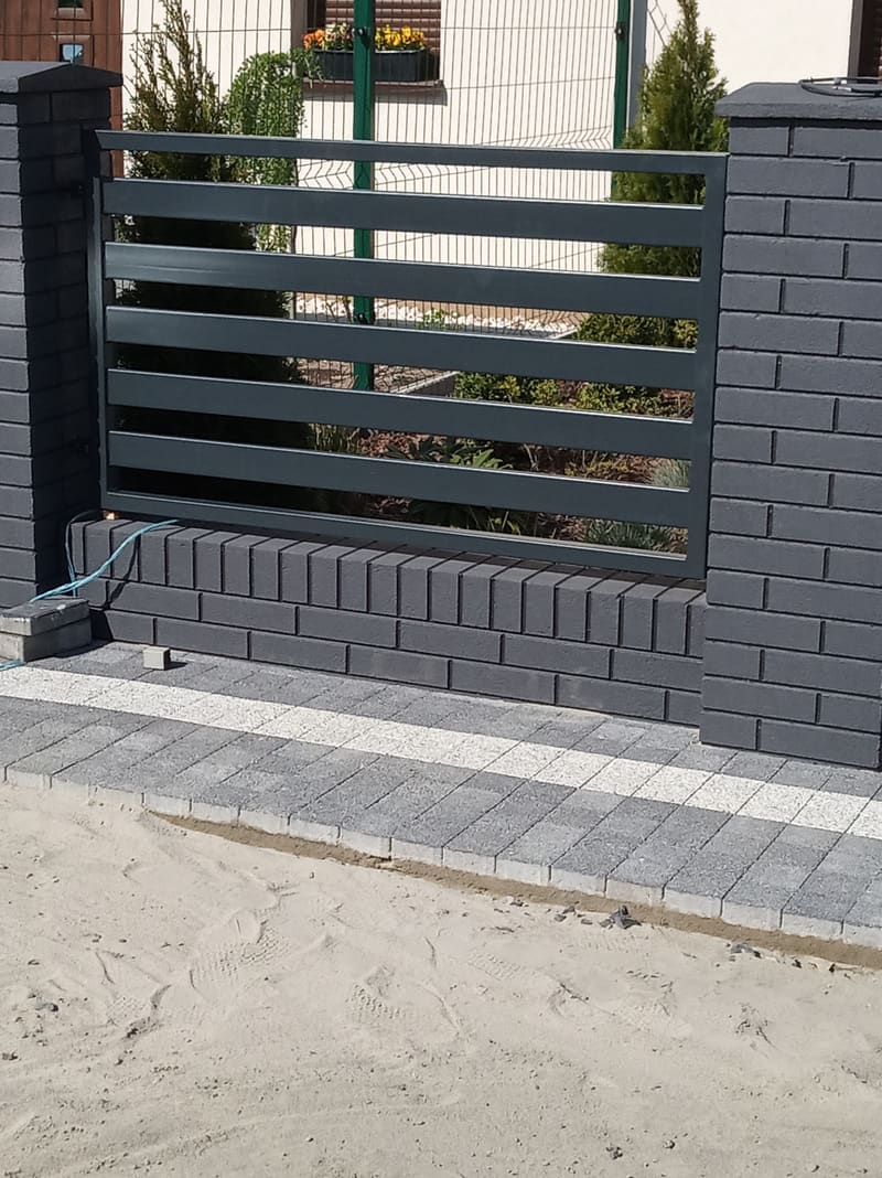 Doprowadzone zasilanie w peszlu i fundament przygotowany pod napęd bramy w nowoczesnym ogrodzeniu