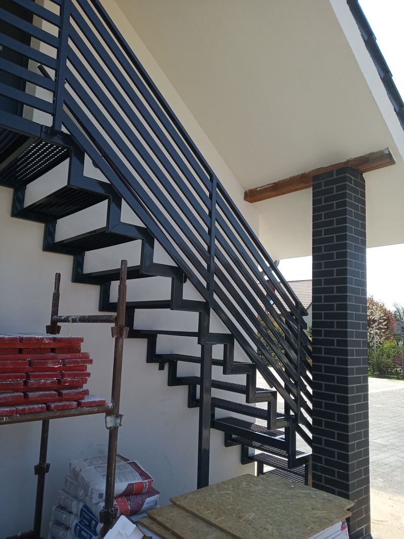Stalowe schody wewnętrzne na policzkach z balustradą i drewnianym pochwytem